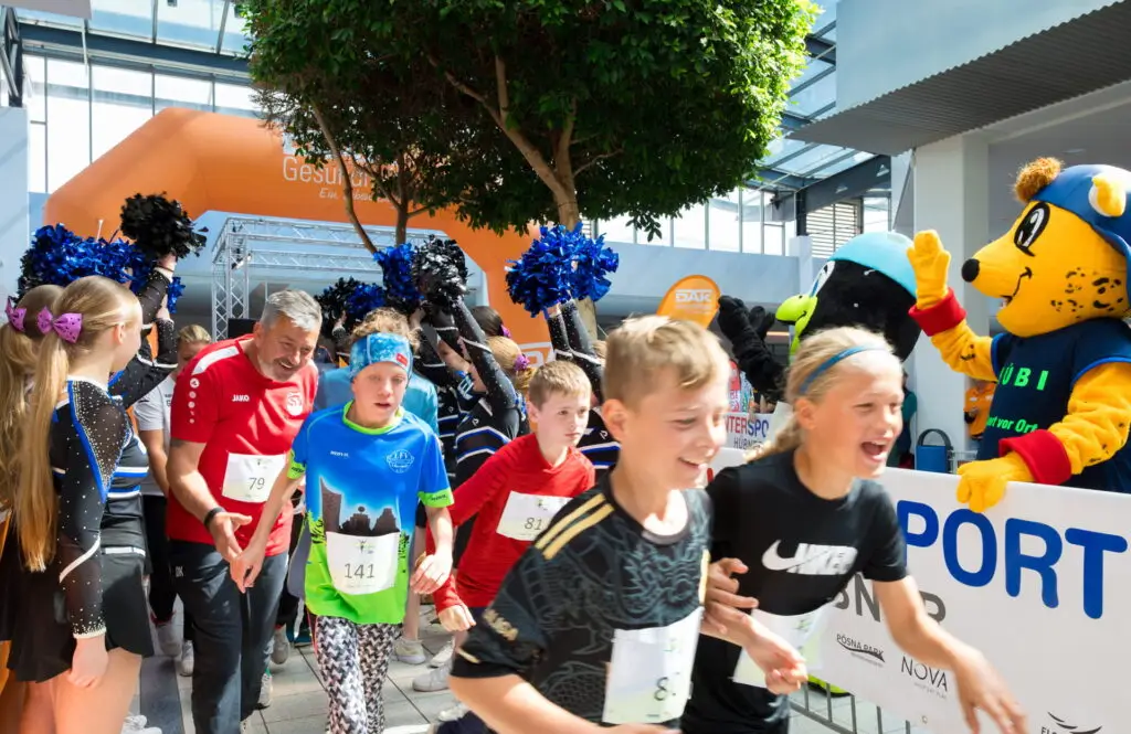 gemeinsam ins ziel. KInder starten bei einem familienfreundlichen Lauf und haben Spaß