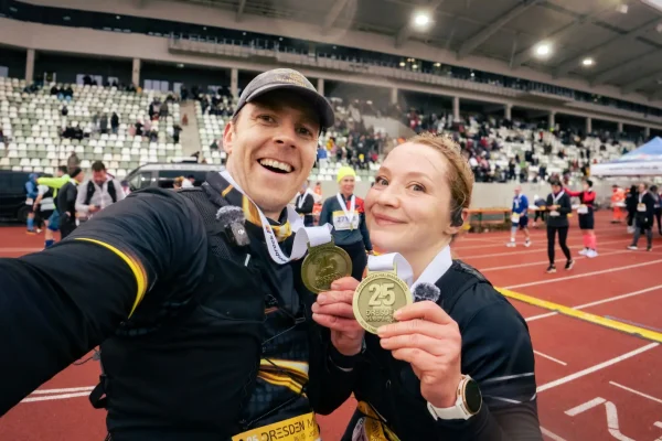 Undine und Erik halten stolz ihre Finishermedaille beim Dresden Halbmarathon 2025 in die Kamera